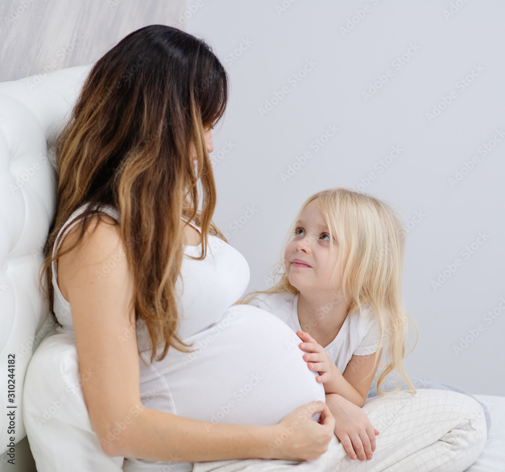 a little girl and her pregnant mom a little girl and her pregnant mom