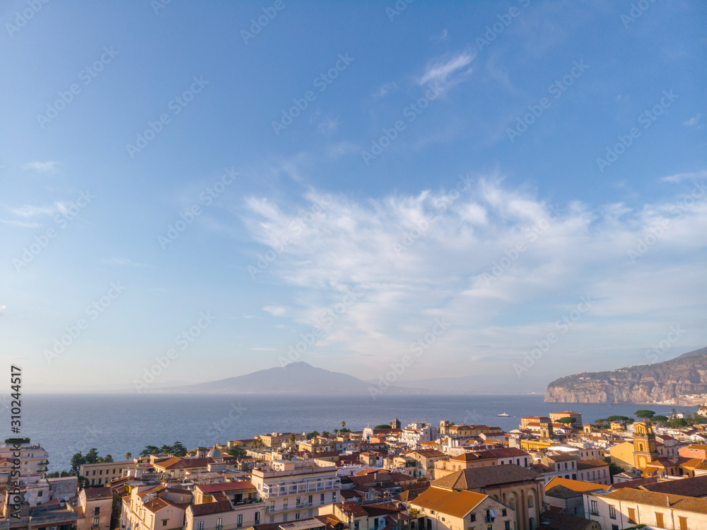 Aerial view on the center of Sorrento city, sunset, houses and streets, sea views and a Vizuvius, Napoli in the distance. Travel and vacation concept on Italy. Infrastructure. Copy space