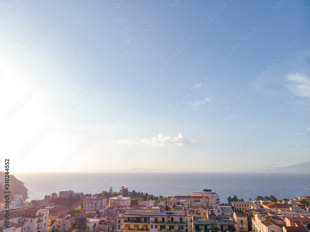 Aerial view on the center of Sorrento city, sunset, houses and streets, sea views and a Vizuvius, Napoli in the distance. Travel and vacation concept on Italy. Infrastructure. Copy space