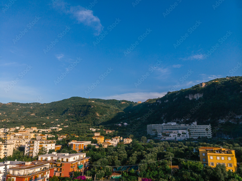 Aerial view on the Sorrento city streets, sunset, houses and Hotels, mountains and buildings in the distance. Travel and vacation concept on Italy. Infrastructure, cars and parking place