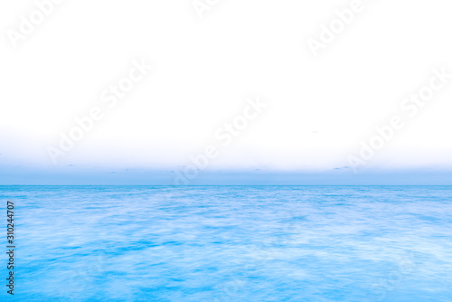 far and away on the ocean, as the horizon is abstractly white and blending into the water 