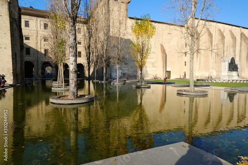 Buildings of the Pilotta in Parma. Fountain with pond and poplar trees. photo