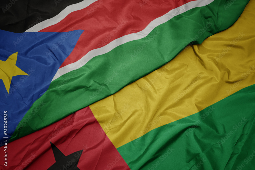 waving colorful flag of guinea bissau and national flag of south sudan.