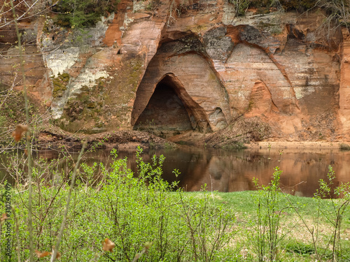 landscape with sandstone cave on the river bank