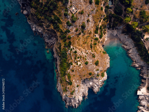 Beautiful top down aerial view of wilderness bay and mountains on sunrise, hiking to a wild beach, tourist destination place for snorkeling and kayaking. Nerano, Massa Lubrense, Ieranto bay, Italy