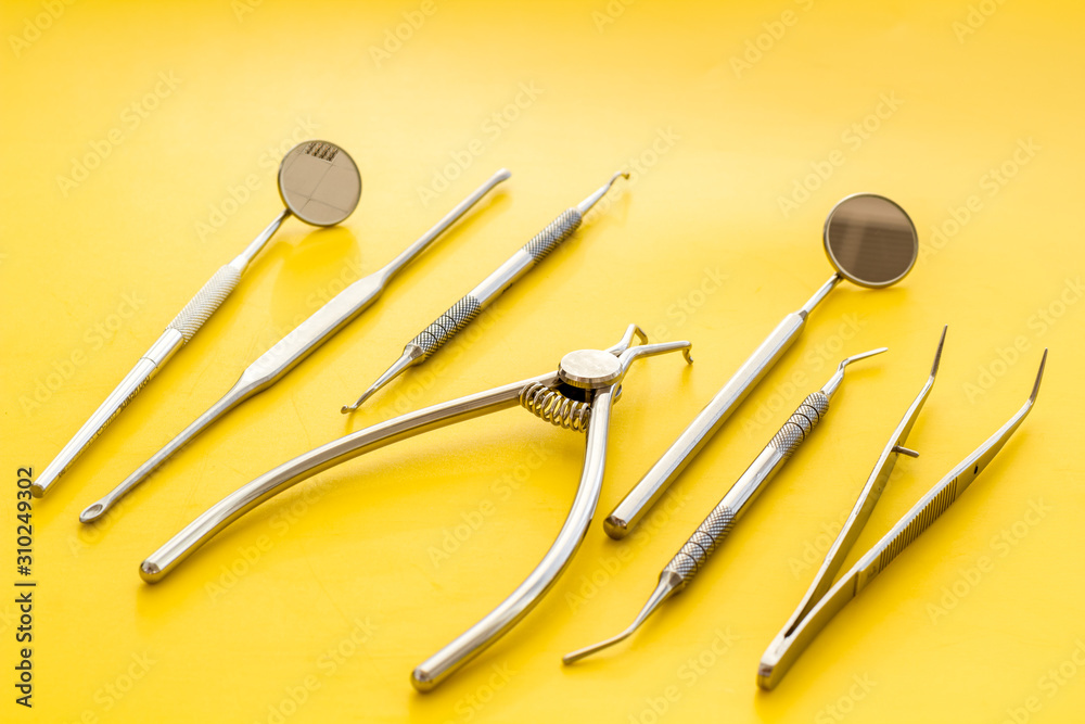 Dental instruments - set with mirrors - on yellow background close up Dental instruments - set with mirrors - on yellow background close up