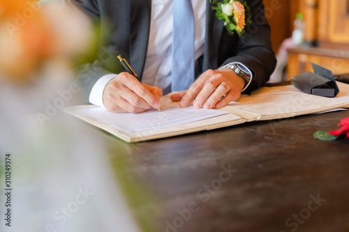 Grooms signs wedding contract, beautiful hands, luxury watch photo