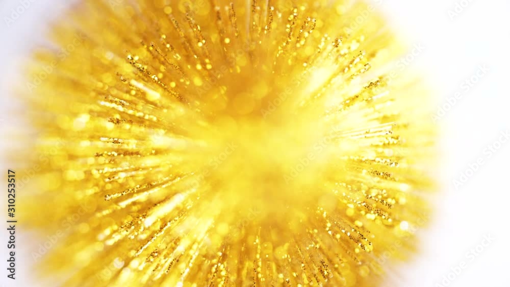 Gold glitter texture surface on white background. 4k close up macro of glittering material. Holiday abstract backdrop.