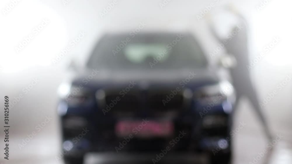 Blurred background.  big blue car at the car wash.