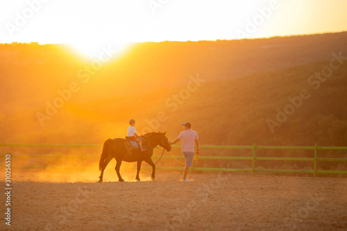 A father teaches his little son how to ride.