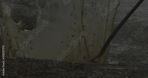 Smashing a shovle into a puddle