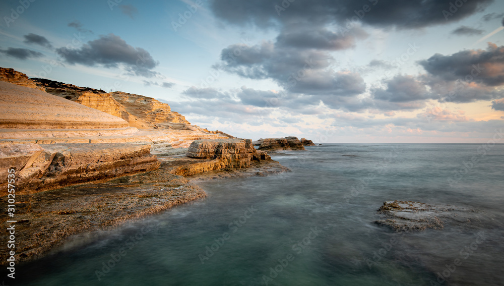 Rocky seashore seascape with dramatic and beautiful sunset at sea caves coastal area  in Paphos, Cyprus