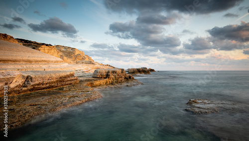 Rocky seashore seascape with dramatic and beautiful sunset at sea caves coastal area in Paphos, Cyprus