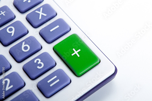 calculator with blue buttons with a green plus sign
