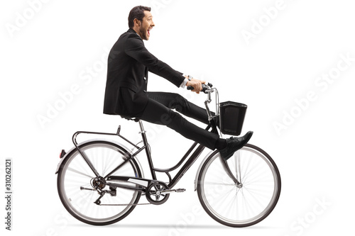 Crazy businessman riding a bicycle with legs up