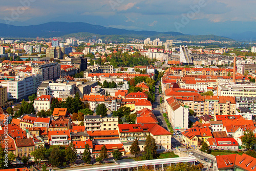 Ljubljana, Slovenia-September 29, 2019:Picturesque aerial view of old part or the city at sunny autumn day. Ancient buildings with red tile roofs, mountain range in the back ground. Vibrant sky