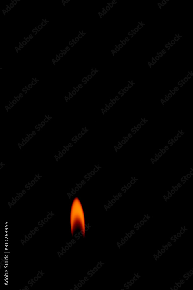 Close-up fire lighter on a black background, candle flame set isolated in black background Close-up fire lighter on a black background, candle flame set isolated in black background