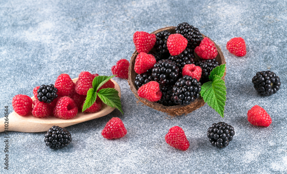 .raspberries and blackberries on a spoon .raspberries and blackberries on a spoon