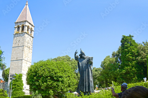 Fototapeta Statue of historic Croatian bishop Grgur Ninski, (Gregory of Nin) and ancient Clock Tower