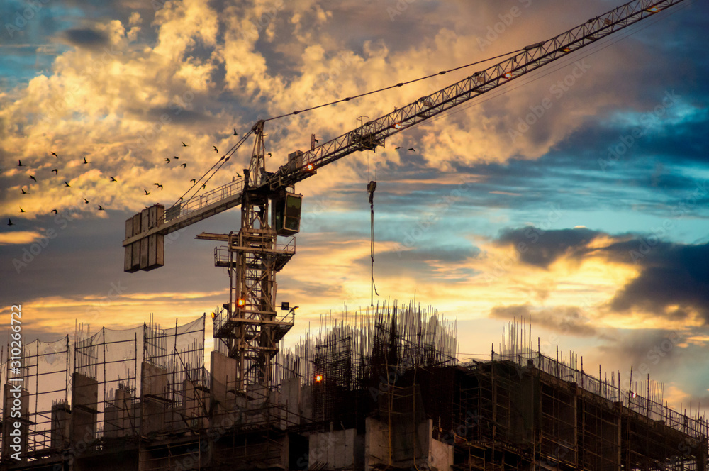 crane on top of an under construction building at dusk