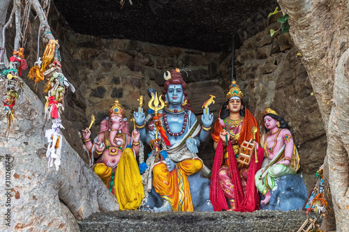 Принти на полотні Colorful figures of Hindu gods in a cave between the roots of trees, Sri Lanka