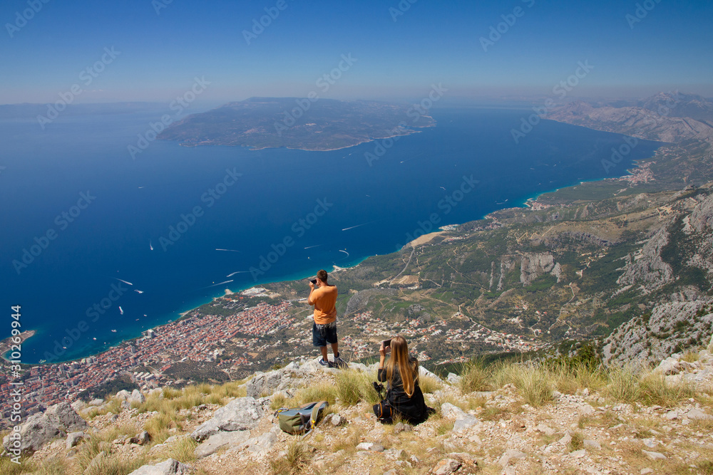 Biokovo national park, Makarska resort panorama, Croatia. Tourists photographing sea view.