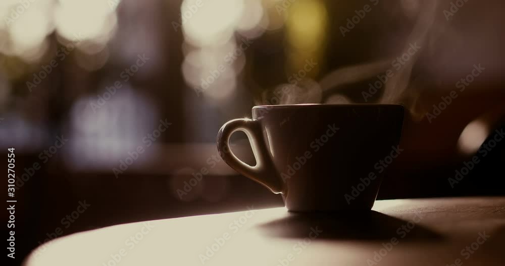 Close up 4K shot of a hot coffee cup with steam coming out of it, in a morning, in Bucharest, Romania.