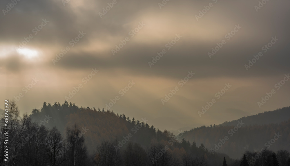 White snowy meadow with Doupovske mountains in mist