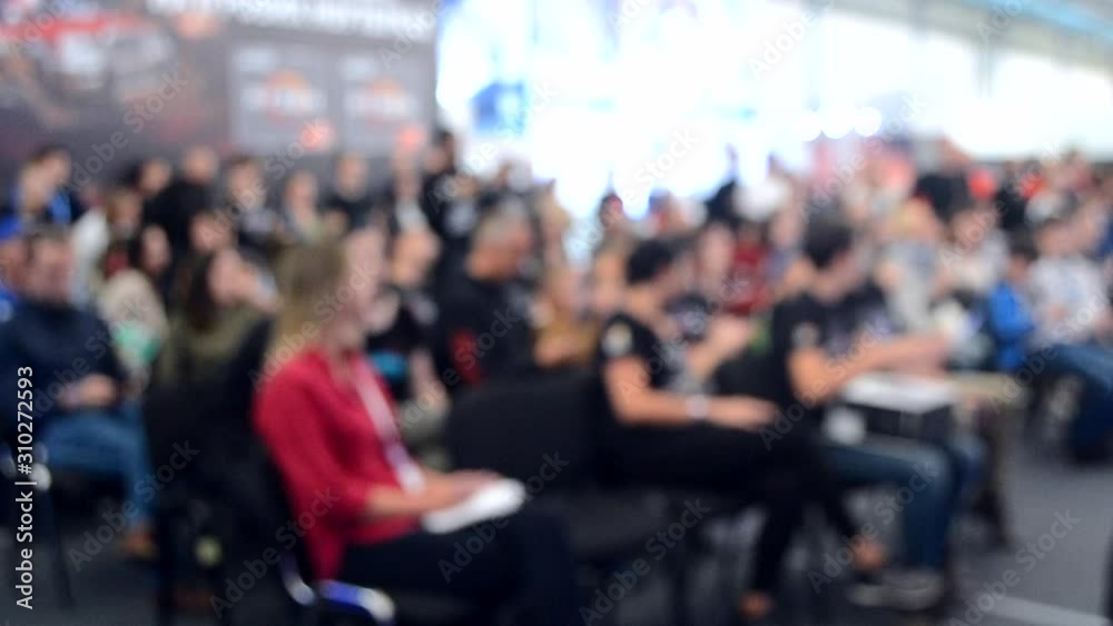 Blurred Background. Many people are sitting in the hall audience