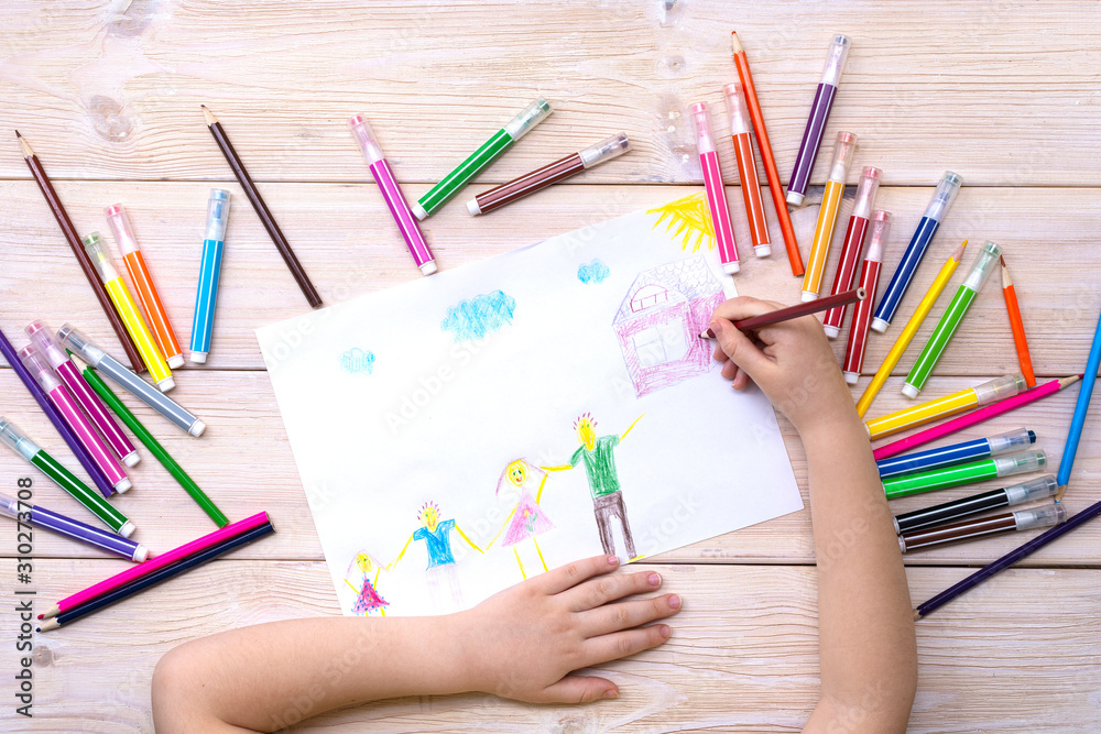 A child draws a birthday card with his family. Drawing made by a child with colorful felt-tip pens and pencils. Happy family. Child's drawing A child draws a birthday card with his family. Drawing made by a child with colorful felt-tip pens and pencils. Happy family. Child's drawing