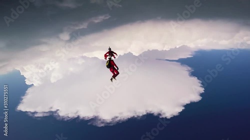 Skydivers jump from airplane. Make formation in blue sky. Extreme sport. Sunny. Professionals