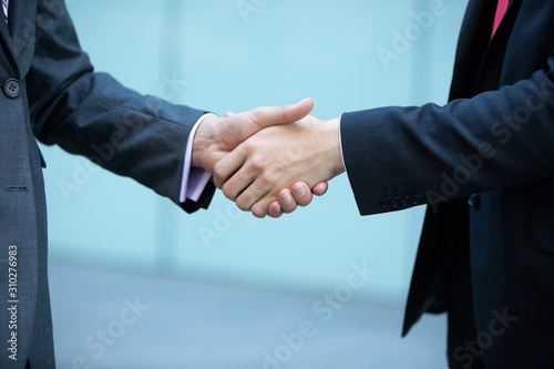 Mid section of business people shaking hands