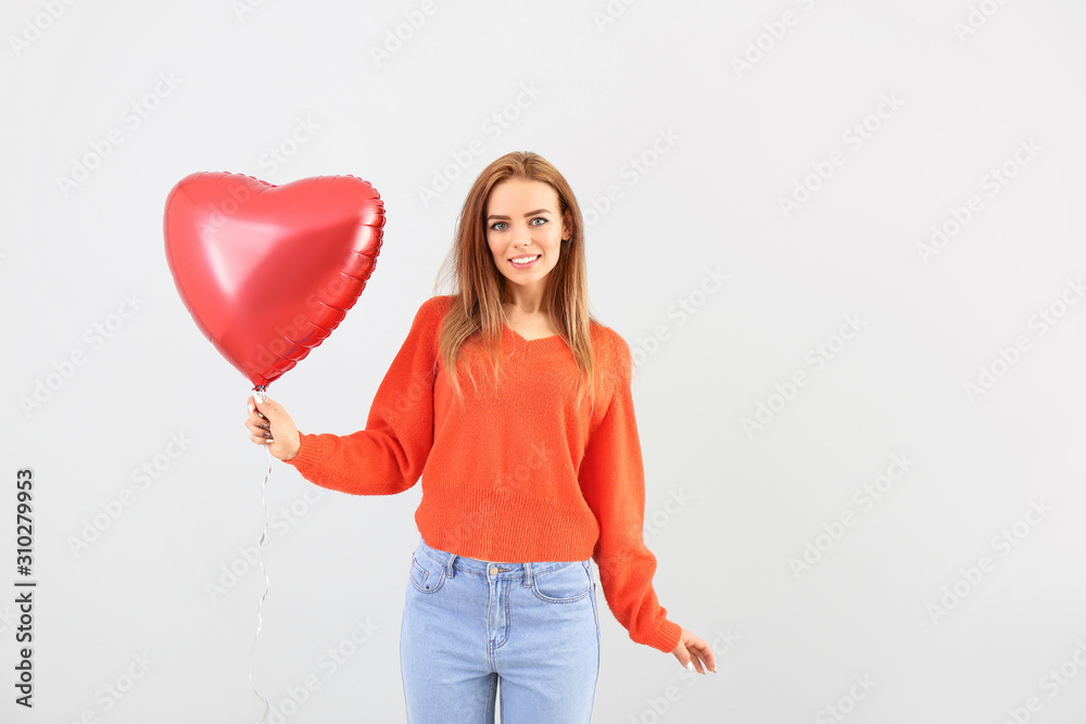 Beautiful young woman with heart-shaped balloon on white background Beautiful young woman with heart-shaped balloon on white background