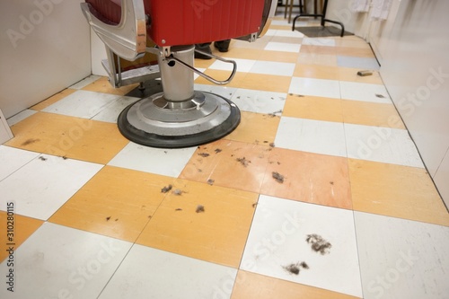 An empty barber shop with cut hair on floor