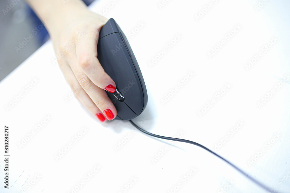 girl's hand uses a vertical ergonomic computer mouse joystick. girl's hand uses a vertical ergonomic computer mouse joystick.