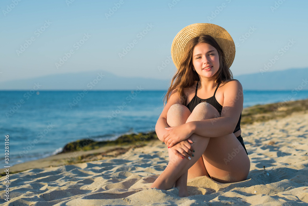 Cheerful plus size teenage girl wearing hat enjoying the beach. smiling, happy, positive emotion, summer style. Cheerful plus size teenage girl wearing hat enjoying the beach. smiling, happy, positive emotion, summer style.