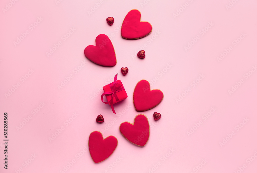 Composition with heart shaped cookies for Valentine's day with gift on color background