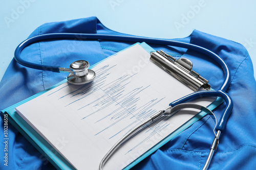 Stethoscope, doctor's uniform and documents on color background. Cardiology c...