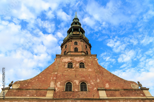 The tower of St. Peter's Church (Sveta Petera Evaņgeliski luteriska baznica)in Riga, Latvia under a blue sky with white fluffy clouds. photo