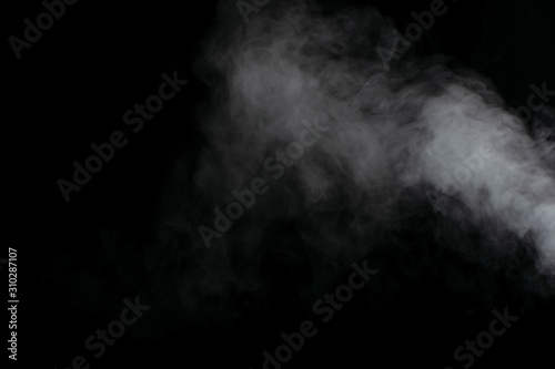 Beautiful puffs of white smoke randomly mixing slowly fill the blackness of the frame