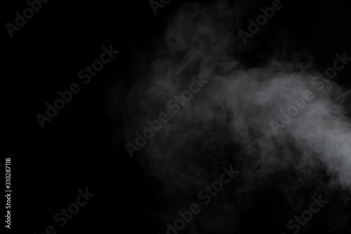 Beautiful puffs of white smoke randomly mixing slowly fill the blackness of the frame