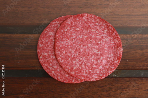 slices of salami on wooden background