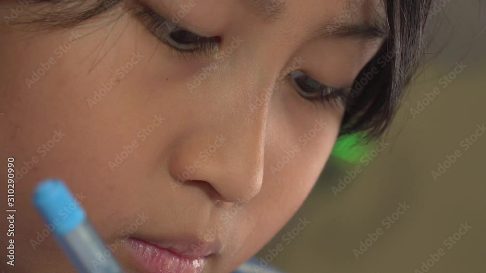 Extreme close up of young asian boy drawing and focusing Extreme close up of young asian boy drawing and focusing