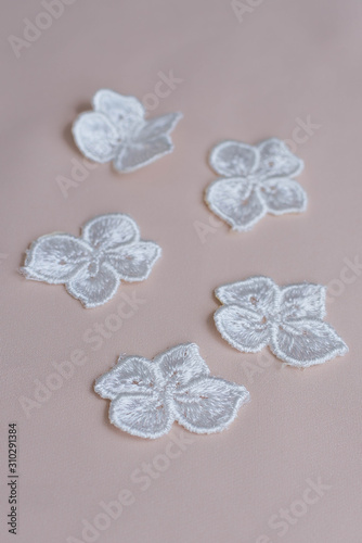 Fototapeta Naklejka Na Ścianę i Meble -  Texture lace fabric. lace on white background studio. thin fabric made of yarn or thread. a background image of ivory-colored lace flowers. White lace on beige background.