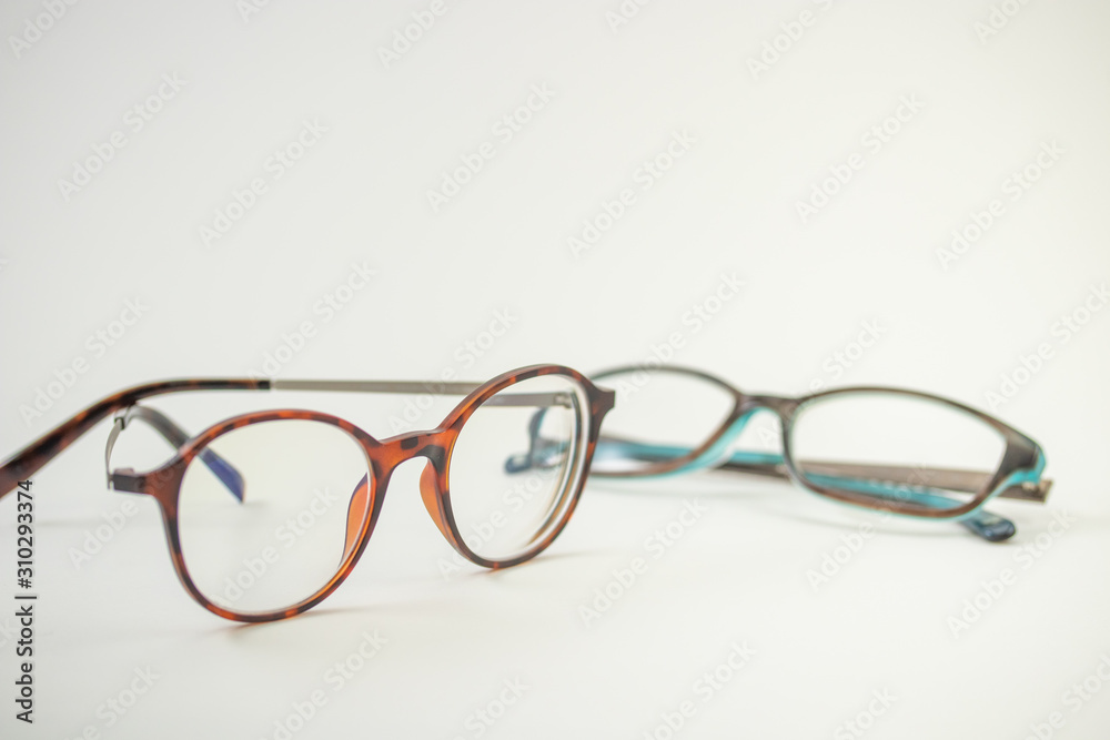Two pairs of modern glasses isolated in a studio shot one with black and turquoise colored frames and a blue blocking pair prescribed from a profession optometrist with isolated white background Two pairs of modern glasses isolated in a studio shot one with black and turquoise colored frames and a blue blocking pair prescribed from a profession optometrist with isolated white background