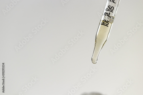 CBD being measured in a clear glass eye dropper for to administer cbd tincture to medical marijuana patient