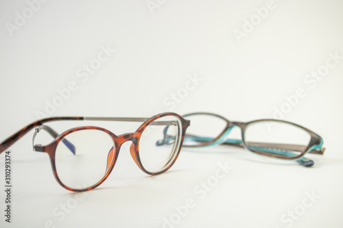 Two pairs of modern glasses isolated in a studio shot one with black and turquoise colored frames and a blue blocking pair prescribed from a profession optometrist with isolated white background 