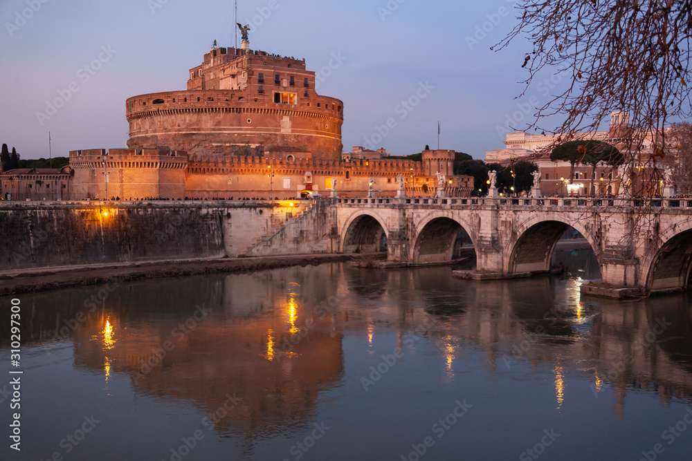 Night view of the bridge Sant'Angelo through the Tiber River and medieval Castle in city center of Rome, Italy