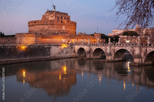 Night view of the bridge Sant'Angelo through the Tiber River and medieval Castle in city center of Rome, Italy