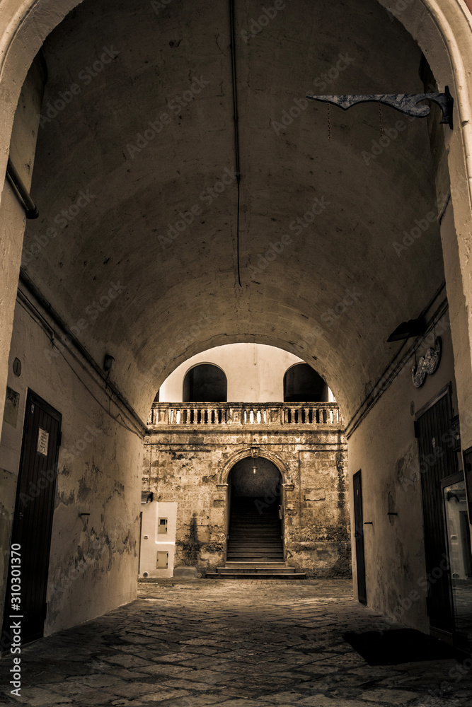 Obraz premium vecchio cortile con archi e scale